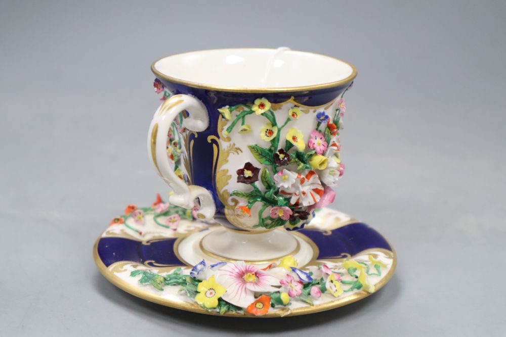 A Bloor Derby floral encrusted two handled cup and saucer, red printed factory mark